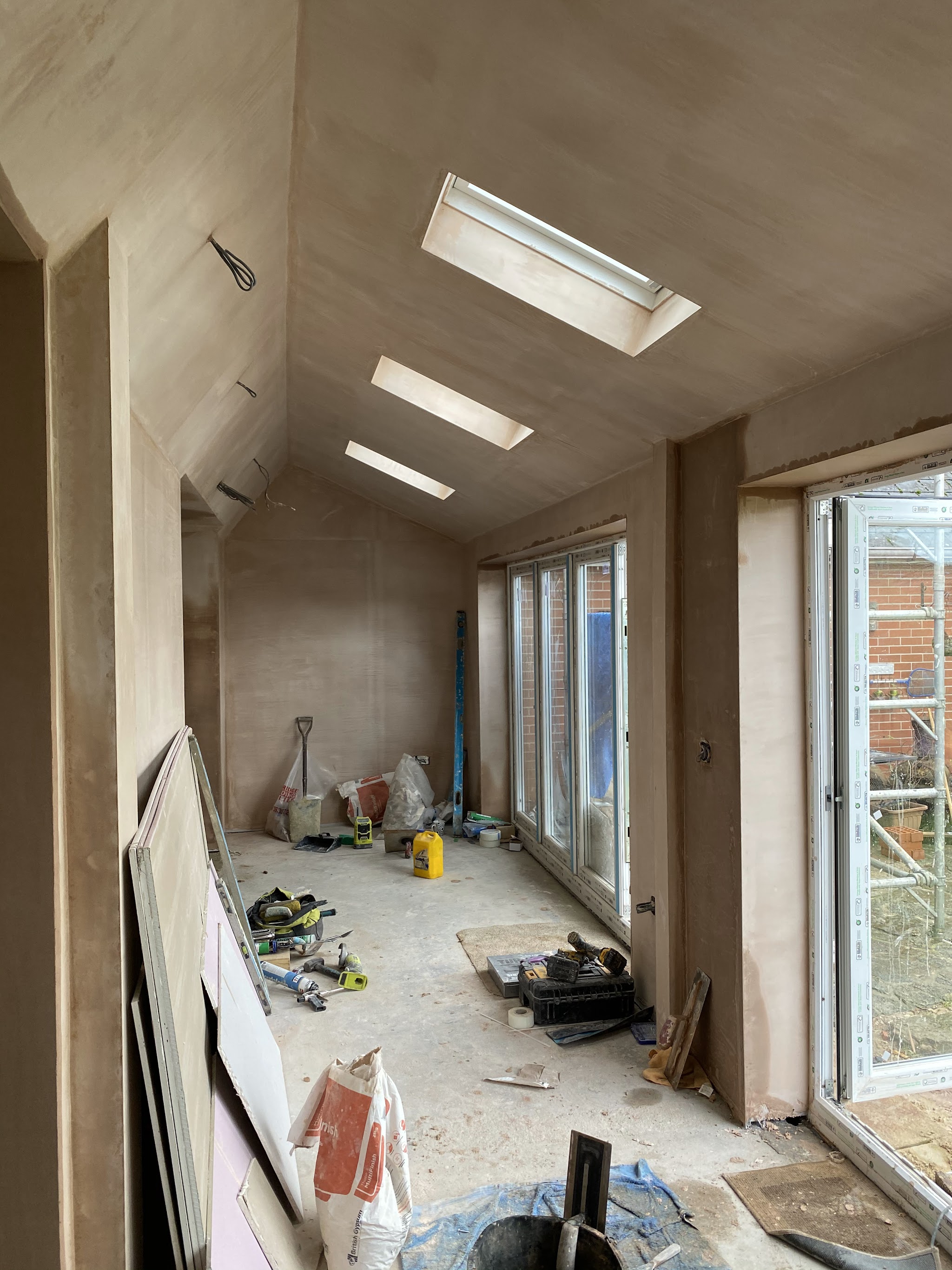 An extension mid-build: vaulted ceiling with roof lights and bi-fold doors going in