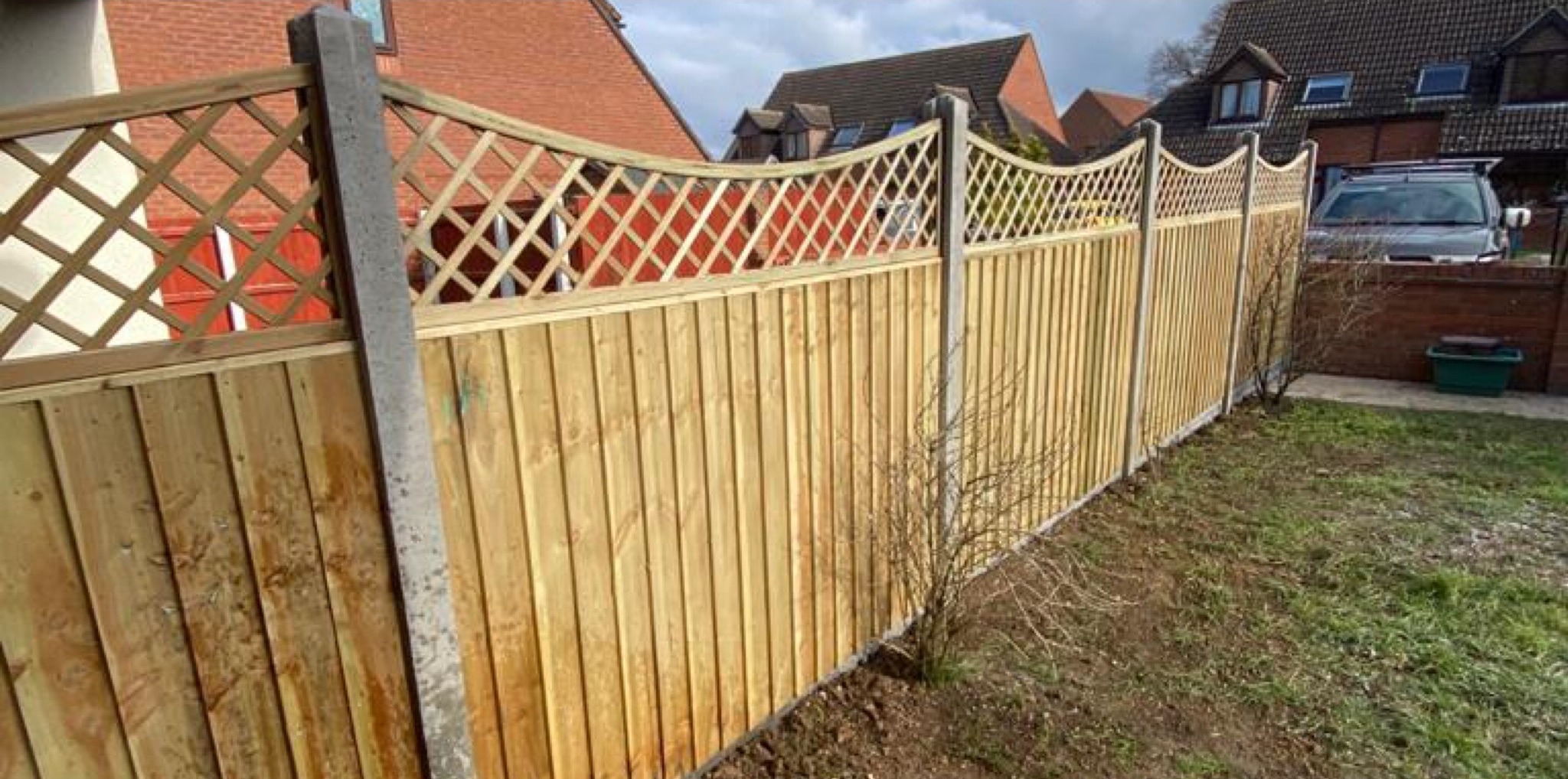 A new closeboard garden fence with a lattice top on concrete posts