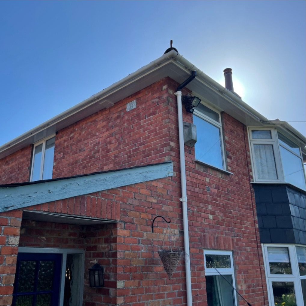 A red-brick house with new white fascias and soffits