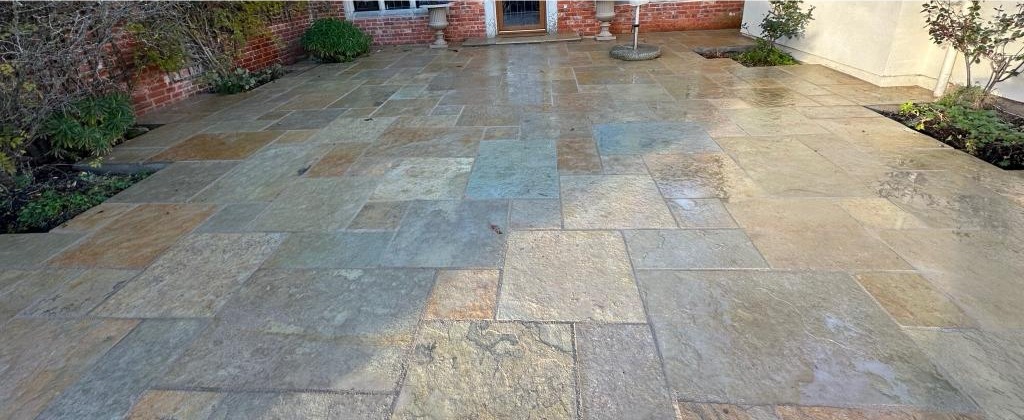 After: the same garden with a new sandstone patio laid